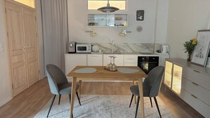 A modern kitchen with a dining area, wooden cabinets, a microwave, and a coffee machine. - Central Park View Apartment with a terrace and lake views features (Dobrich)