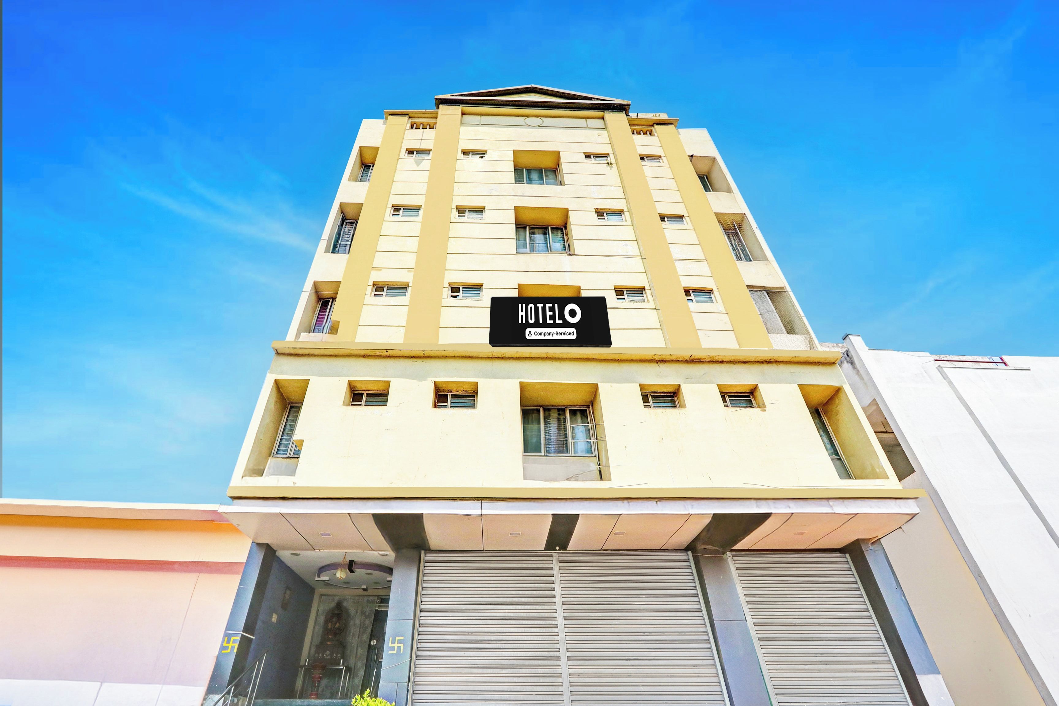 Un edificio de hotel con un letrero que dice 'HOTELO' y un rótulo de servicio de la empresa.