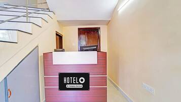 A hotel reception desk with a sign indicating it is company-serviced.