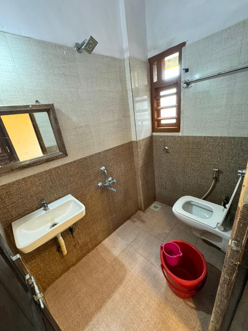 A small bathroom with a sink, toilet, and a window.