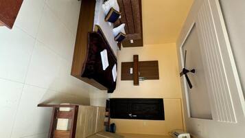 A staircase leading to a room with a bed, a wooden bench, and a wall-mounted shelf.
