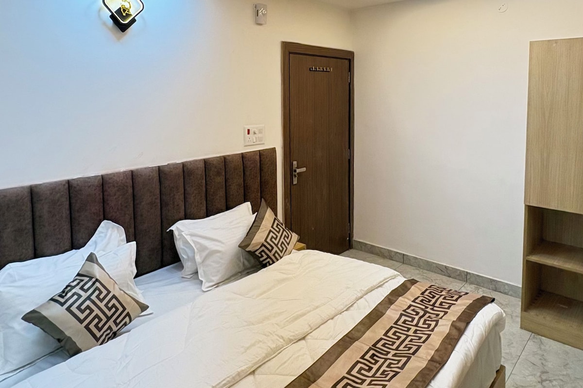 Un dormitorio con cama, ventilador de techo, iluminación empotrada, una puerta y un armario.
