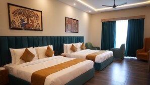 A hotel room with two beds, a large window with curtains, a ceiling fan, and artwork on the walls. - Hotel Oriva (Aligarh)