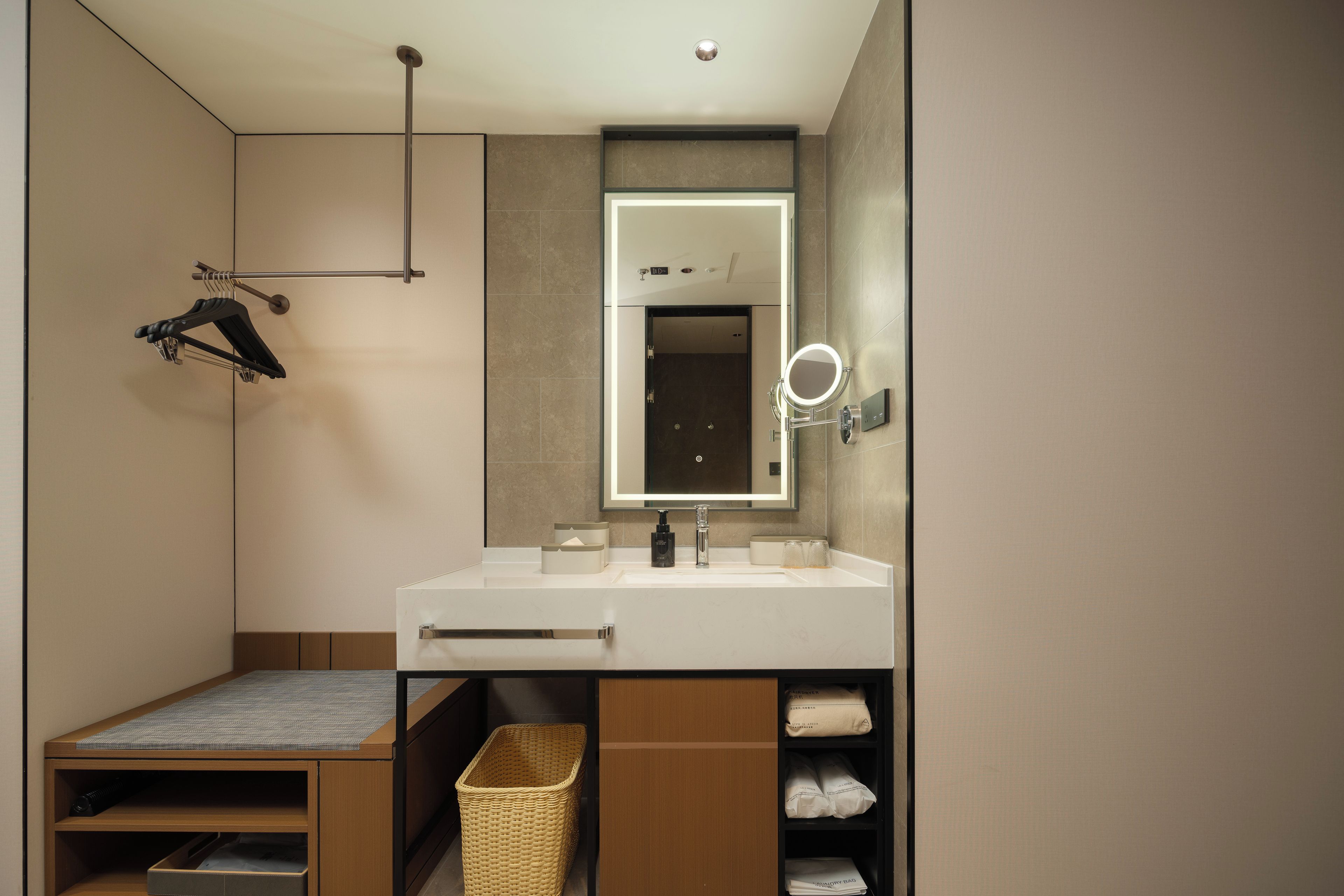 Un baño moderno con tocador, espejo y perchero.