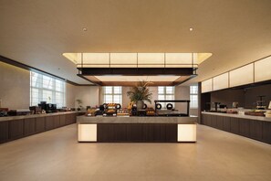 A spacious, modern kitchen with a central island, ample counter space, and large windows providing natural light.