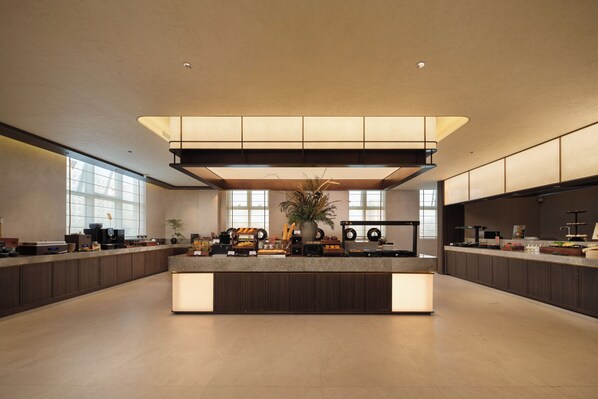 A spacious, modern kitchen with a central island, ample counter space, and large windows providing natural light.