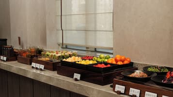 Mostrador de buffet con diferentes alimentos y etiquetas.
