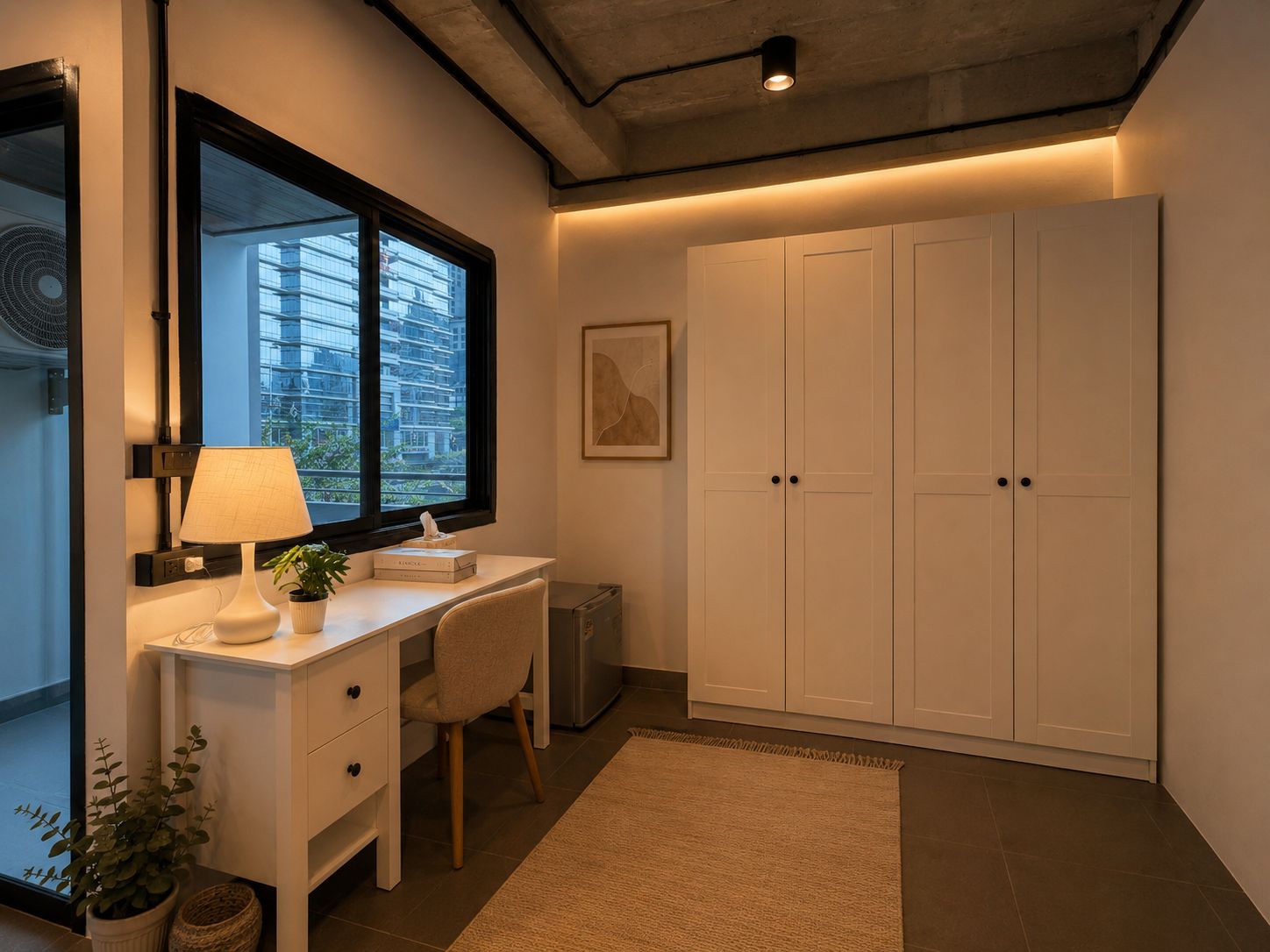 Een kamer met een bureau, stoel, lamp, potplant en een grote garderobe.