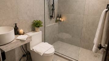 A modern bathroom with a glass shower enclosure, a toilet, a sink, and a window providing natural light.