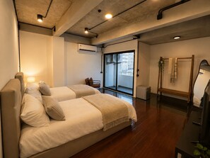 A hotel room with a bed, a small table, a mirror, and a view of the city. - Time2Sleep (Krung Thep Maha Nakhon)