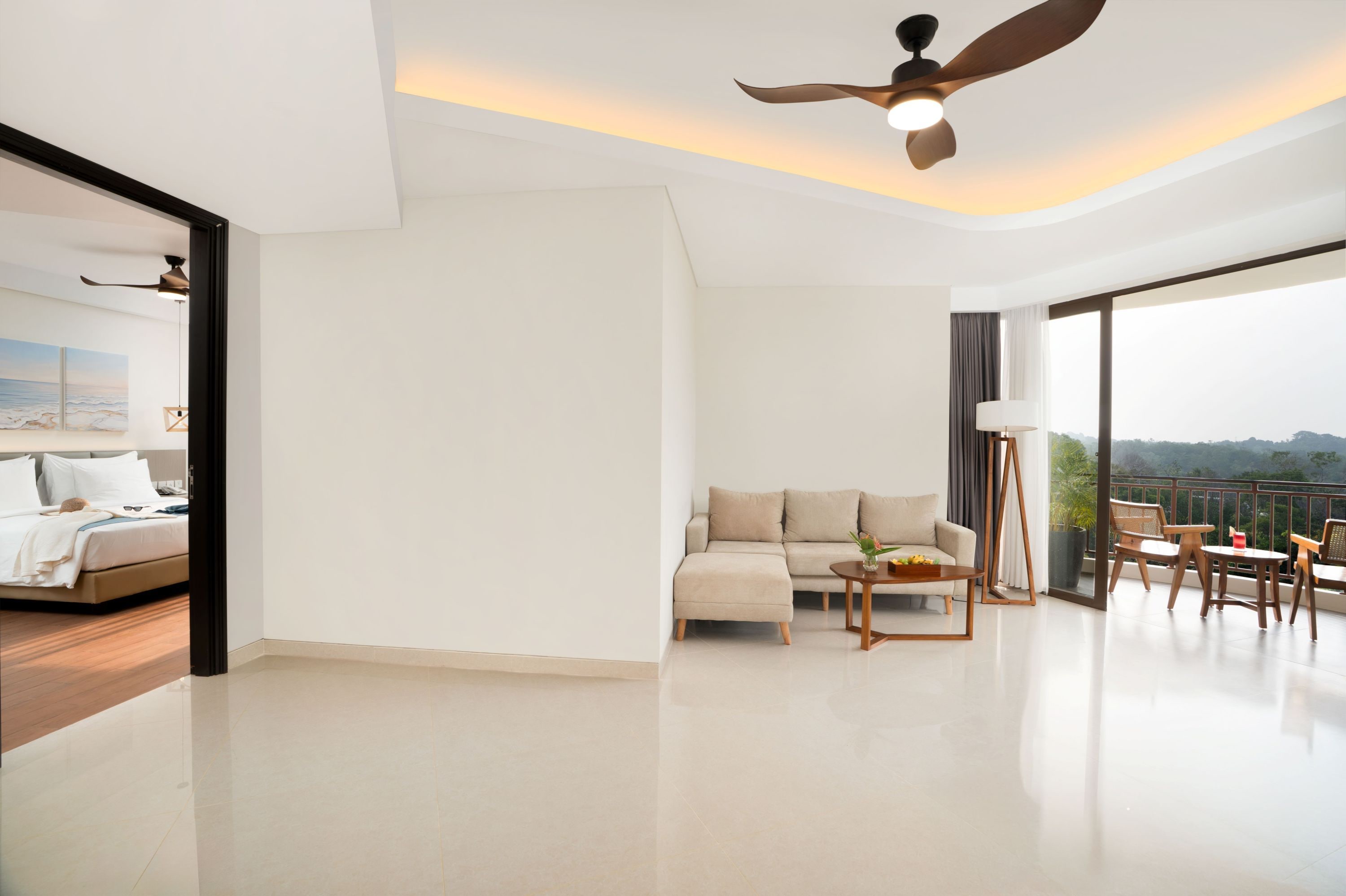 Une chambre d’hôtel moderne dotée d’un balcon, d’un canapé, d’une table à manger et d’un ventilateur de plafond.