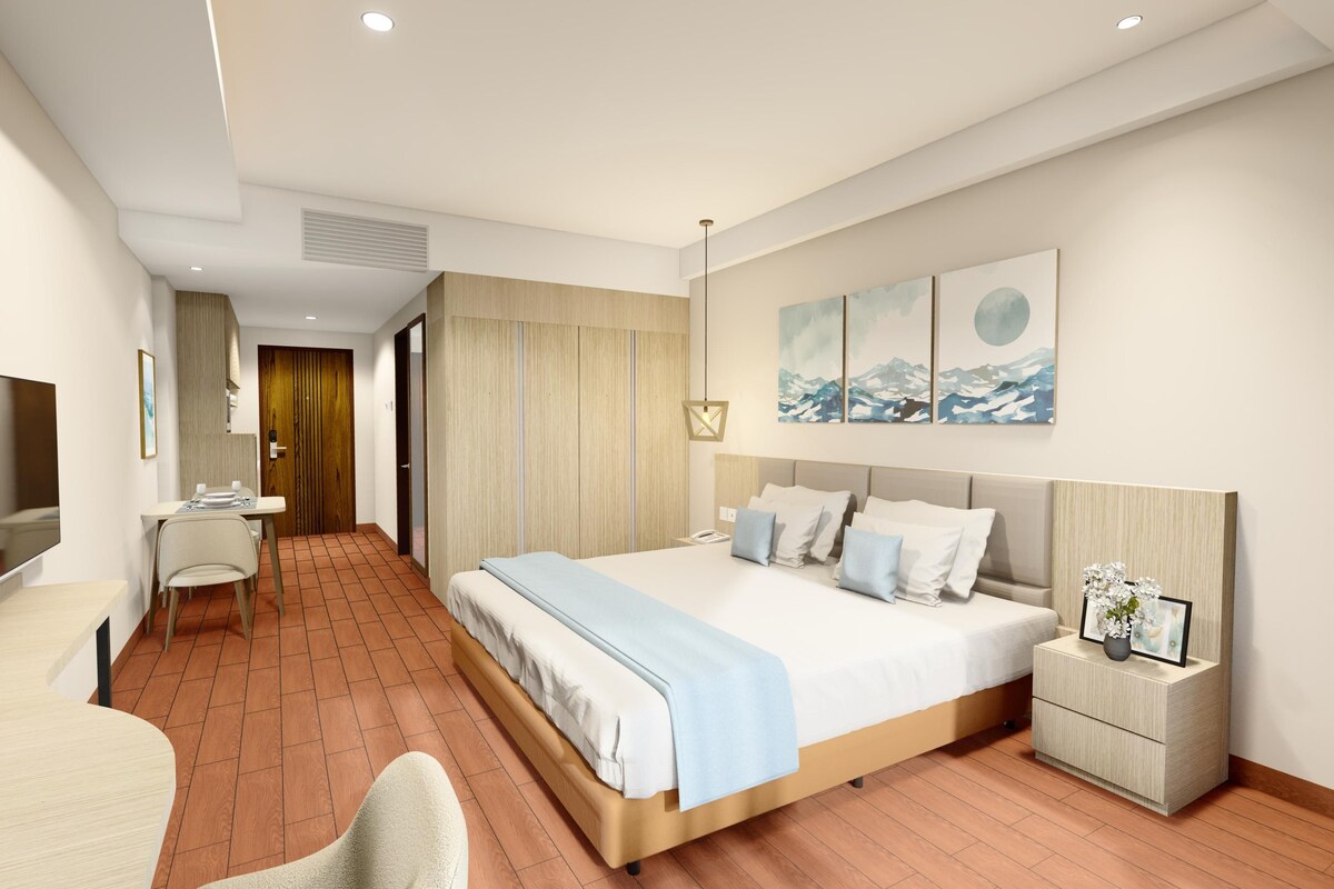 A modern hotel room with a bed, bedside table, and a TV.