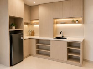 A modern kitchen with a built-in refrigerator, a sink, and wooden cabinets.