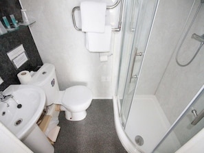 A bathroom with a toilet, sink, and shower. - Standard Triple Room (Eastbourne)