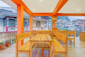 Un área de estar con bancos de madera y vista a una zona residencial.