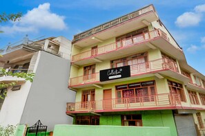 Un edificio de varios pisos con balcones y un cartel que indica que es una colección de apartamentos de empresa.