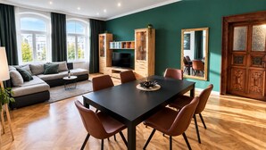 Ein modernes Wohnzimmer mit Essbereich, großen Fenstern und einer Holzkabine.