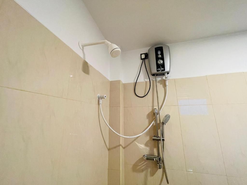 A shower with a handheld showerhead and a wall-mounted control unit.