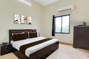 A hotel room with a bed, bedside table, and a wardrobe. - Hotel O Yamuna Riverview Swyamwar Resort (Mathura)
