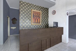 A reception area with a patterned wall, a clock, and a sink. - Spacious Triple Suite for Groups With Free Wifi (Yogyakarta)