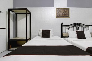 A bedroom with a four-poster bed, two single beds, and a nightstand. - Spacious Triple Suite for Groups With Free Wifi (Yogyakarta)