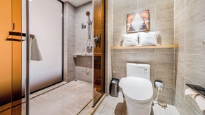 Ein modernes Badezimmer mit Duschkabine aus Glas, Toilette und Waschbecken.