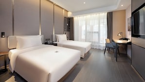 A hotel room with two beds, a desk, a chair, a TV, and a large window with curtains. - Atour Hotel Dalian Xinghai Square (Dalian)