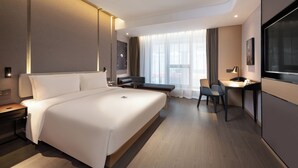 A modern hotel room with a large bed, a desk, and a TV. - Atour Hotel Dalian Xinghai Square (Dalian)