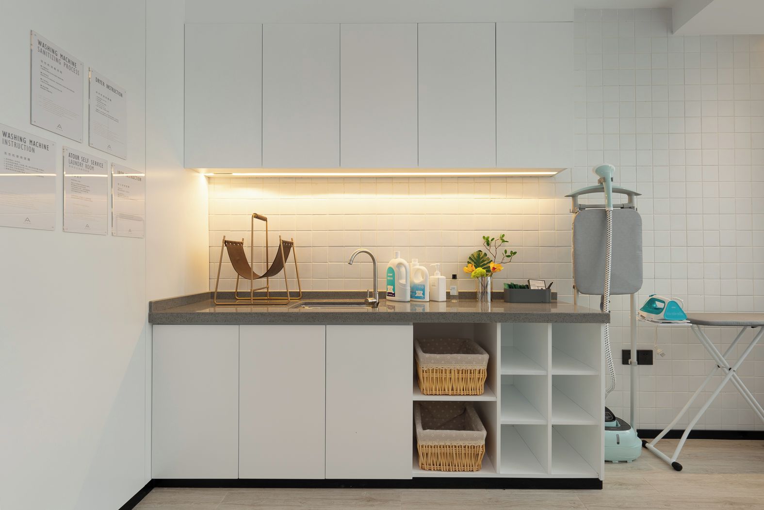 Una cocina moderna con lavadora integrada, sala de lavandería autoservicio y estación de planchado.
