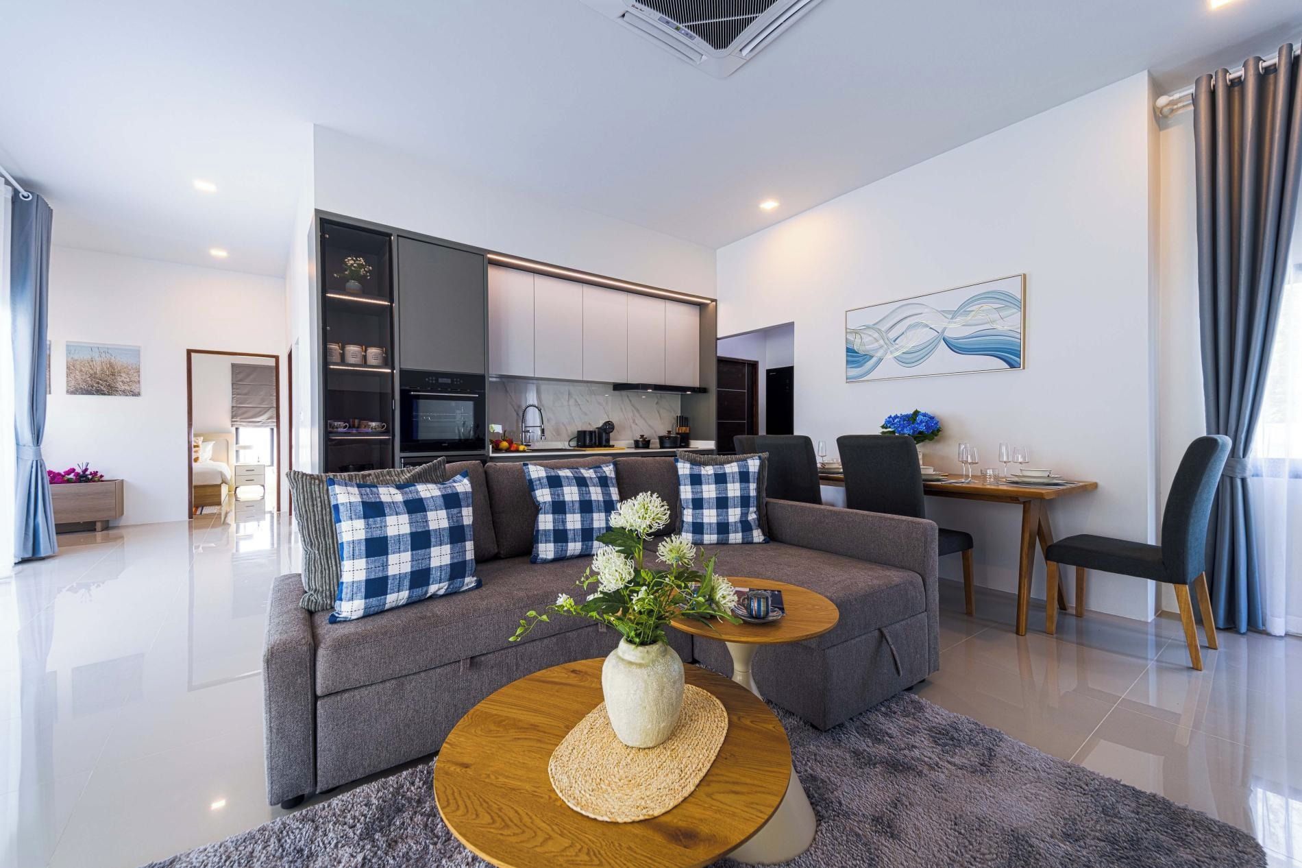 Uma sala de estar moderna com sofá, mesa de centro e área de jantar.