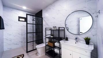 Een moderne badkamer met toilet, wastafel, douchecabine en spiegel.