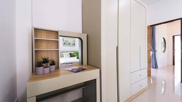Una habitación moderna con escritorio integrado, estanterías y armario.