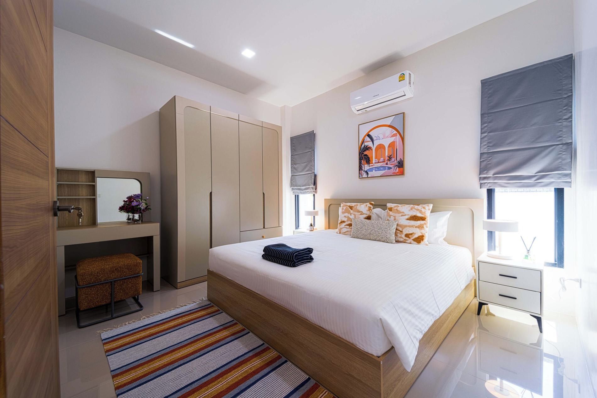 Habitación de hotel moderna con una cama grande, un armario, un tocador con espejo y una ventana con vistas.