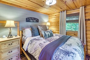 Een gezellige slaapkamer met een bed, twee nachtkastjes, een wandklok en een bordje met de tekst 'The Best Place To Be Is Together'.