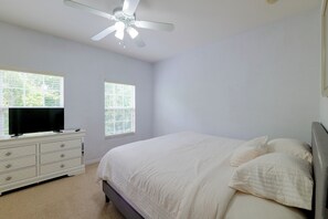 A bedroom with a bed, dresser, television, and windows. - Resort Pool, Lanai! Family Retreat Near Disney (Kissimmee)