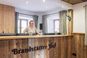 A reception desk with a wooden finish and the text 'Brandstätter Hof' on it. - Double Room No. 14, shower and toilet, balcony, TV, Wi-Fi (Ruhpolding)