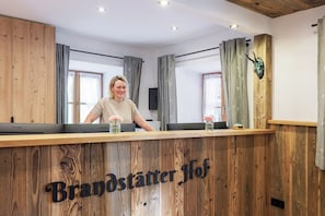 Ein Empfangstresen mit Holzoptik und dem Schriftzug 'Brandstätter Hof'.