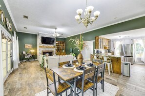 A dining area with a wooden table, chairs, and a chandelier.
