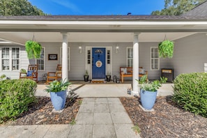 A house with a porch, potted plants, and a blue door. - Game Day Hideaway! Spacious Opelika Escape (Opelika)