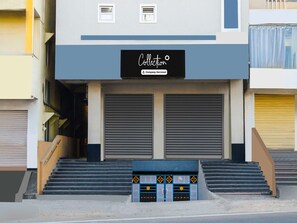 Ein Gebäude mit einem Schild, auf dem 'Collection Company-Serviced' steht. Es gibt zwei große Garagentore und eine Treppe zum Eingang.