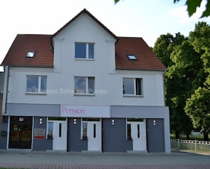 A two-story building with a flat roof and a sign indicating it is a pension. - Pension Schwarze Pumpe (Spremberg)