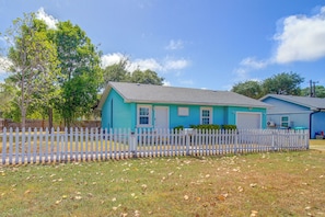 A single-story house with a blue exterior and a white picket fence. - Corner Cottage - Just Minutes from the Water (Aransas Pass)