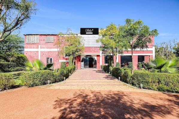 A building with a red brick facade, a cross, and a sign that reads 'Collection'.