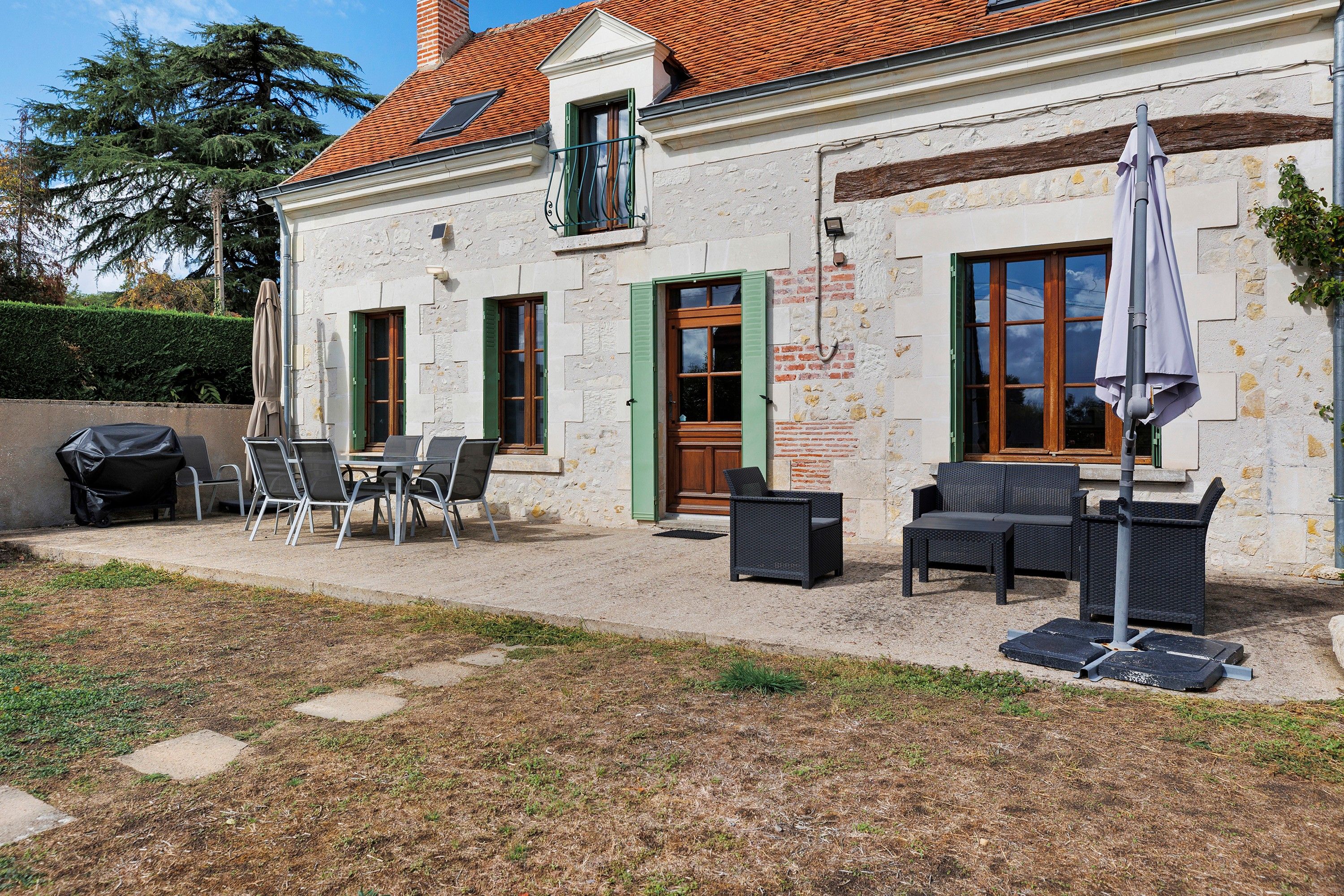Un bâtiment doté d’un patio aménagé avec du mobilier d’extérieur et un barbecue.