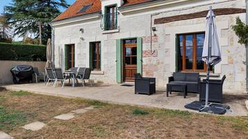 Un bâtiment doté d’un patio aménagé avec du mobilier d’extérieur et un barbecue.