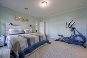 A bedroom with a bed, a treadmill, and a door leading to another room. - Waterfront Interlachen Retreat w/ Dock on Lake Ida (Interlachen)
