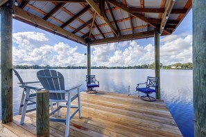 A wooden deck with two Adirondack chairs facing a calm lake. - Waterfront Interlachen Retreat w/ Dock on Lake Ida (Interlachen)