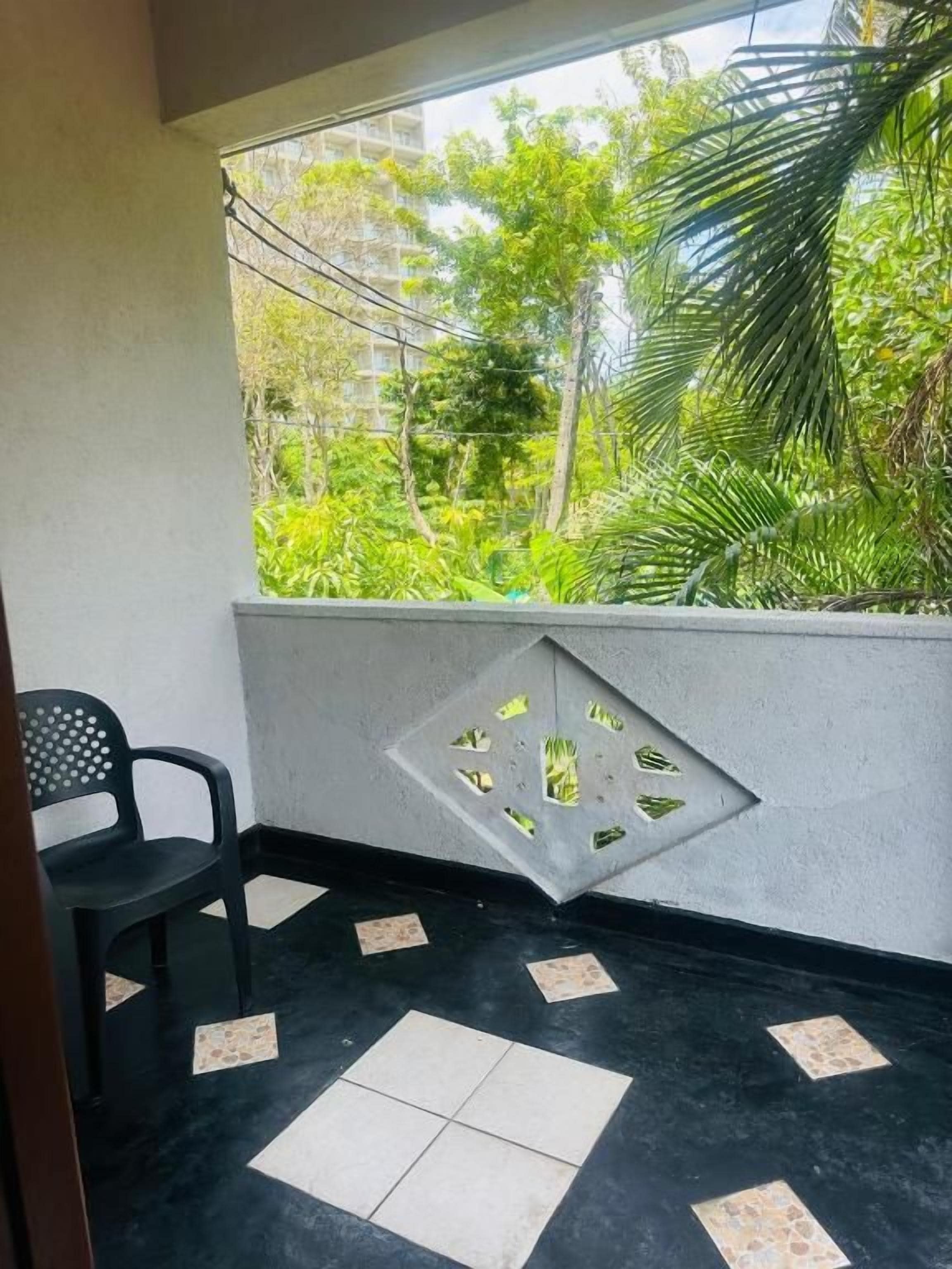 Un balcón con vistas a zonas verdes y un diseño de pared geométrico.