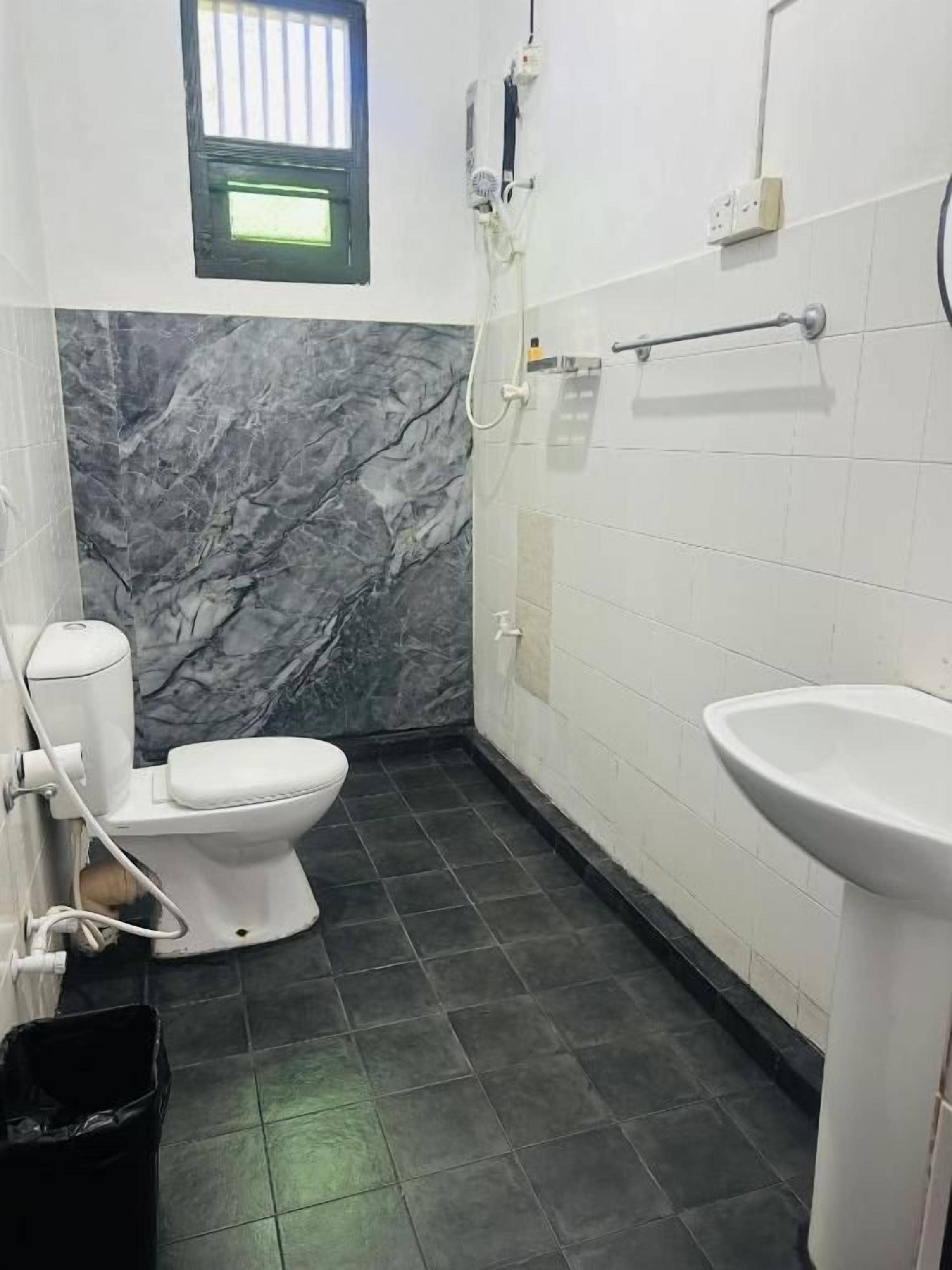 A bathroom with a toilet, sink, and shower.