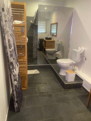 Une salle de bain moderne équipée d’une douche, de toilettes et d’un lavabo.